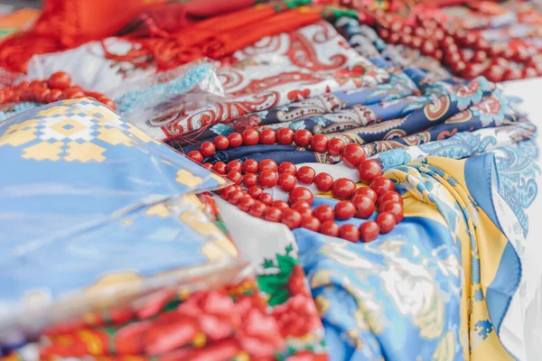 Folk ukrainian style scarves with floral patterns. Traditional Ukrainian ethnic style jewelry made with ceramic beads. Exclusive handmade necklaces at souvenir stall or street Sunday market. Selective focus