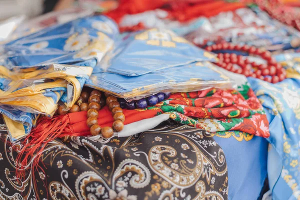 Folk ukrainian style scarves with floral patterns. Traditional Ukrainian ethnic style jewelry made with ceramic beads. Exclusive handmade necklaces at souvenir stall or street Sunday market. Selective focus