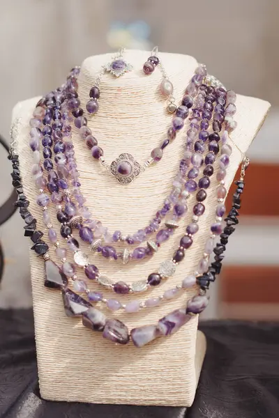 Folk ukrainian style scarves made of amethyst. Traditional Ukrainian ethnic style jewelry. Exclusive handmade necklaces at souvenir stall or street market. Selective focus.