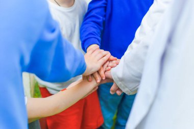 Bir grup çocuk ellerini birleştiriyor. Bir sürü arkadaş, oyunlar. Seçici odak