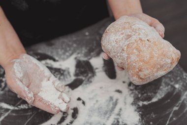 Ellerinde taze pişmiş ev yapımı ciabatta ekmeği olan tanınmayan kadın elleri.