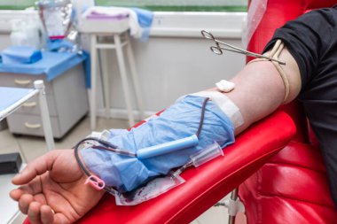 Kan bağışında bulundu. Ayrıca Dünya kan bağışı günü için konsept görüntü. Kanını bağışlayan adam koltukta yatarken rahatça kan veriyor..