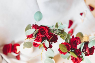 Romantik bir akşam yemeği için dekor. Kırmızı güller, yapraklar ve mum.