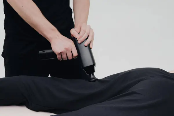 stock image Massage therapy session featuring a practitioner using a handheld device on a client's back in a calming environment