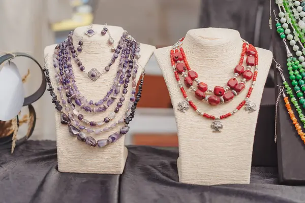 Sıcak öğleden sonra güneşinin altında hareketli bir pazar yerinde sergilenen zarif el yapımı mücevherler.