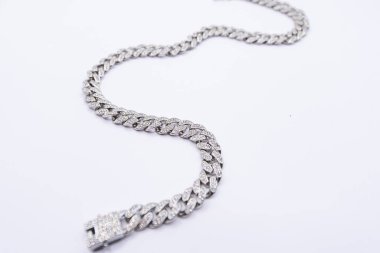 Beyaz arka planda pırlanta kaplı bir bileziğin ayrıntılı görüntüsü zarafetini ve ustalığını gözler önüne seriyor.