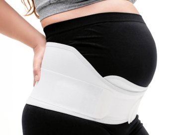 Hamile bir insan, destek ve rahatlık için beline hamilelik destek kemeri takar. Dekorasyon, sıradan bir iç mekan olduğunu gösteriyor. Bu kemer sırt ağrısını hafifletmeye yardımcı olur..