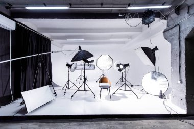 Entellektüel siklonama fotoğraf stüdyosu, beyaz arkaplan, birden fazla ışıklandırma ayarları, yansıtıcılar ve yaratıcı fotoğrafçılık projeleri için bir sandalye..