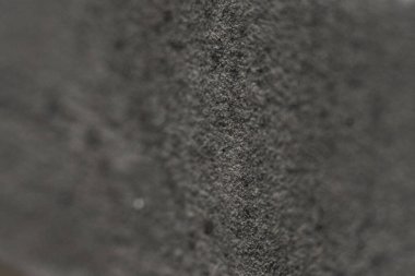 Kaba siyah bir yüzeyin detaylı bir görüntüsü ince dokuları ve ince desenleri ortaya çıkarır. Bu yakın plan doğal mineral oluşumlarını sergiliyor, jeolojik güzellikleri vurguluyor..