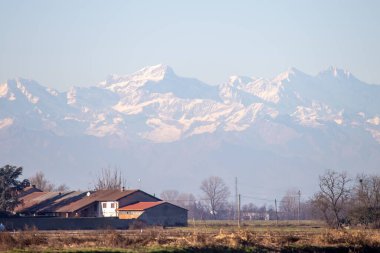 Karlı tepeleri ve kırsal bölgeleri olan manzaralı dağ manzarası