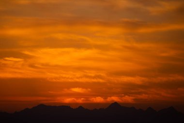 Turuncu Gökyüzü ve Siluetli Dağ Sırasıyla Güzel Günbatımı
