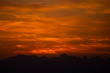 Çarpıcı Günbatımı Silueti Dağlar ve Canlı Turuncu Gökyüzü