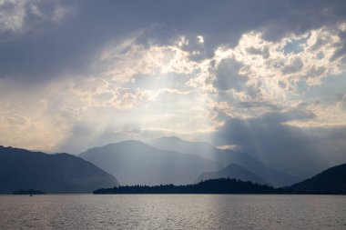 Huzurlu Dağ manzarasının üzerindeki Bulutların Arasında Güneş Işıkları Kırılıyor
