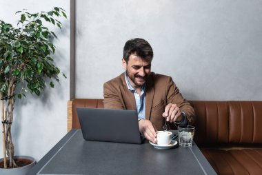 Genç iş adamı serbest finans uzmanı öğle yemeği ve kahve molasını bilgisayardaki mutlu müşterisiyle iş hakkında konuşmak için kullanıyor. Ofis ekibiyle iş görüşmesi