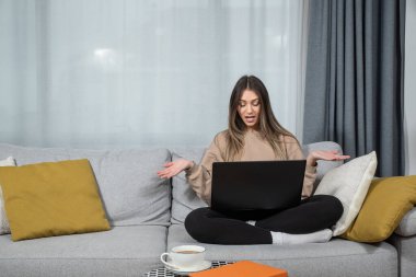 Bir psikologla çevrimiçi istişare, evde oturan, kanepede oturup ağlayan, bilgisayarla video görüşmesi yapan, depresif bir kadınla oturma odasında görüşen genç bir kadın..