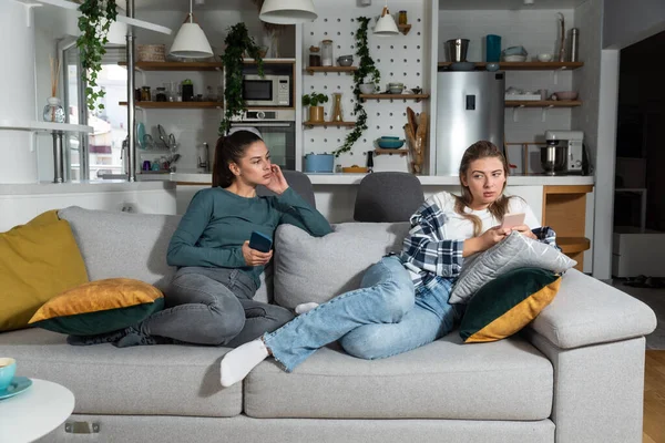 stock image Young lesbian couple at home have a problem and argue due to jealousy caused by chatting and flirting via social media networks on smart phones, relationship difficulties problems and distrust.