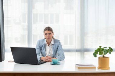 Sinirli ve kızgın serbest çalışan iş kadını görüntülü konuşma, kadının tartışması ve dizüstü bilgisayara bakması, online iş konferansı. Ofis masasında oturan, şık giysili bir kadın.