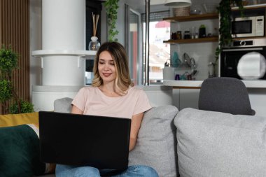 Genç iş kadını ev tasarımcısı yeni bir daire alan müşterisi için dizüstü bilgisayarı üzerinde çalışıyor. Dişi Feng Shui uzmanı bilgisayar tasarımına bakıyor..