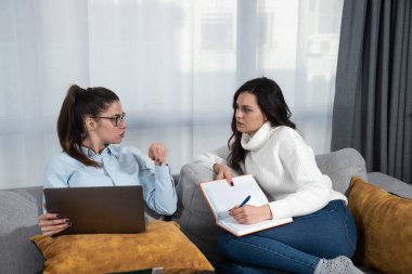 İki başarılı genç bayan arkadaş ve iş ortağı, şirketlerinin istatistiklerini bir dizüstü bilgisayardan izliyorlar ve küçük şirket hisselerinin hisse senedi piyasasındaki değerini yükseltiyorlar..