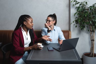 Genç ve başarılı serbest çalışan kadınlar kafeteryadan dizüstü bilgisayarla çalışıyor ve özgürlüğün tadını çıkarıyorlar. Kahve dükkanında çalışan yeni küçük işletme sahipleri.