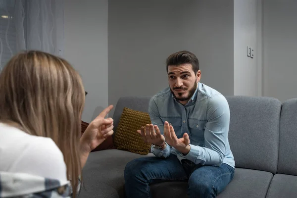 Young married couple husband and wife sitting at home having problems in their marriage and a cold relationship. A boyfriend and a girlfriend have an argument about spending too much money.