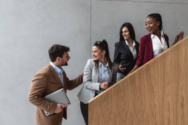 Group of young successful business people on stairs of office building happy with new ideas and satisfied with work support each other in teamwork finished staff meeting