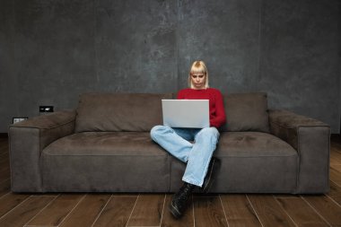 Young girl freelancer expert in programming web design marketing and advertising work on laptop computer in the waiting room called by company to which she responded to the ad for a job interview