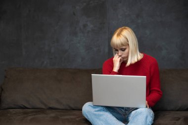 Young girl freelancer expert in programming web design marketing and advertising work on laptop computer in the waiting room called by company to which she responded to the ad for a job interview