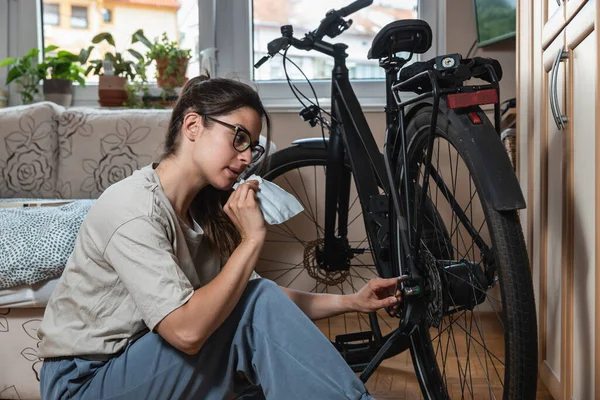 Young beautiful responsible environmental activist woman is repairing and preparing her bike for spring and summer because she doesn\'t want to pollute the air