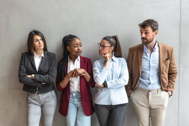Group of young business people colleagues freelancers experts leaders of different professions in a company of marketing and financial experts standing leaning against wall with different attitude