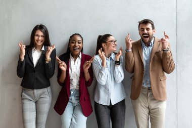 Group of young business people colleagues freelancers experts leaders of different professions in a company of marketing and financial experts standing leaning against wall with different attitude