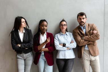 Group of young business people colleagues freelancers experts leaders of different professions in a company of marketing and financial experts standing leaning against wall with different attitude