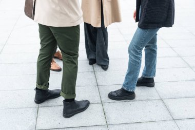 Tanımlanamayan iş adamları bir ofis binasının önünde grup halinde duruyorlar. Akıllı giyinme fikri yenilikleri ve taktikleri, bilgi ve istatistikleri paylaşan iş adamlarının vücut parçaları