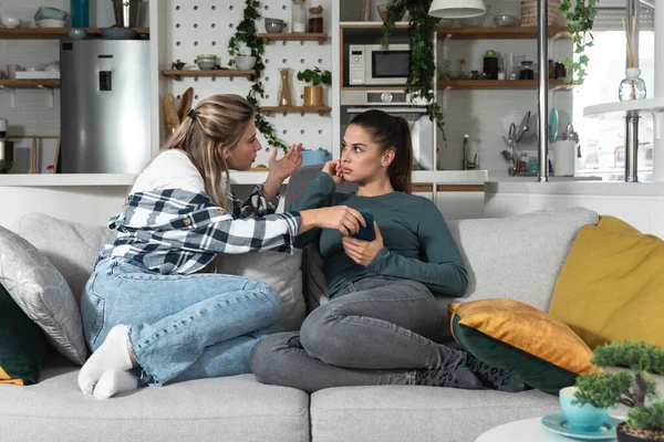 stock image Young lesbian couple at home have a problem and argue due to jealousy caused by chatting and flirting via social media networks on smart phones, relationship difficulties problems and distrust