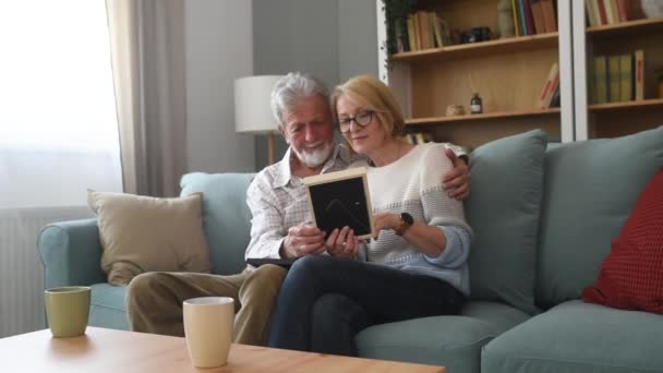 Δύο Ηλικιωμένοι Ηλικιωμένοι Άνδρες Και Γυναίκες Που Κοιτούν Ένα Οικογενειακό — Αρχείο Βίντεο