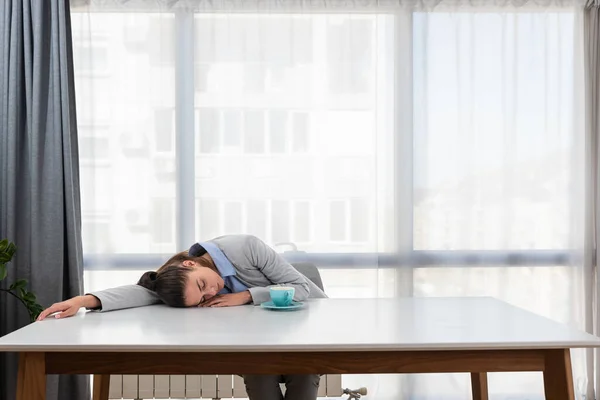 Tired businesswoman sleeping on table in office. Young exhausted female working from home. Entrepreneur, business, freelance work, student, stress, work from home overworked concept