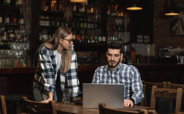 İki farklı girişimci şık kahvecilerinde takım toplantısı düzenliyor. Barista ve Kafe Sahibi Laptop Bilgisayar 'da Çalışma Programı ve Menüsü' nü tartıştı. Çok ırklı Kadın ve Erkek Restoran Çalışanları.