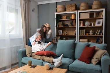 Mutlu üç kuşak aile kucaklaşması evde oturup, 70 'lerin babası ve 50' lerin anne sıcak akrabaları olan yetişkin bir kızı ile birlikte eğleniyor. Nesiller arası akrabalar arası akrabalar kavramı.