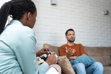 Stresli endişeli adam depresyon ve anksiyete danışmanı profesyonel yardım psikoterapisi sağlıyor. Mutsuz erkek hasta danışmanlığı psikologla, terapi yardımı alarak.