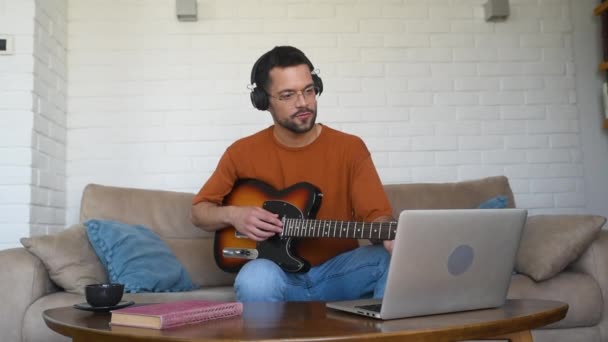 Νέοι Άνδρες Μουσικός Αρχάριος Φορώντας Σύγχρονα Ακουστικά Μαθαίνουν Παίζουν Κιθάρα — Αρχείο Βίντεο