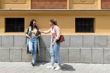Moda kıyafetleri içinde gülümseyen iki güzel hippi kadın. Sokakta poz veren kaygısız kadın arkadaşlar. Pozitif modeller eğleniyor, konuşuyor, sohbet ediyor, iletişim kuruyor. Deliriyorum