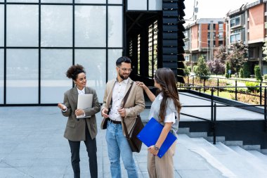 Toplantıdan önce kısa bir brifing. Bir grup neşeli ve başarılı iş adamı dışarıda yürürken birbirleriyle konuşuyorlar. Ofis çalışanları fikir ve çözüm alışverişinde bulunuyor