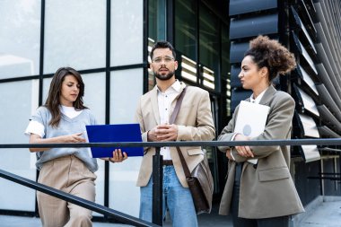 İş ortakları iş arkadaşları takım ve personel üyesi yaz tatilinden önce toplanıp tartışırlar. İki iş kadını stratejisi uzmanına sahip bir işadamı ofis binası dışında konuşuyor.