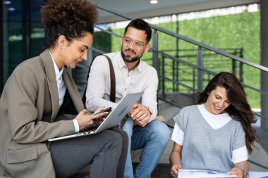 İş ortakları iş arkadaşları takım ve personel üyesi yaz tatilinden önce toplanıp tartışırlar. İki iş kadını stratejisi uzmanına sahip bir işadamı ofis binası dışında konuşuyor.