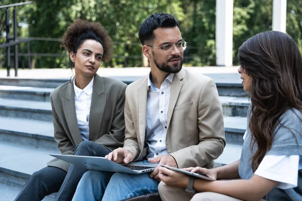 Bir grup iş adamı ofis binalarının önünde yürüyor. İş adamı ve iki iş kadını, başarılı bir strateji ve pazarlama için deneyim ve taktik paylaşıyorlar. İşçiler mola veriyor..