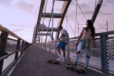 Gülümseyen hippi insanlar dışarıda birlikte vakit geçiriyorlar. Genç milenyum çifti güneşli akşamın ve yaşam tarzının tadını çıkarıyor..