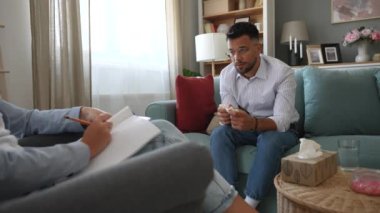 Depresyonda olan genç bir adam ofiste ruh sağlığı danışmanıyla konuşurken ağlıyor. Boşandıktan sonra psikoterapi gören stresli bir erkek. Duygusal hasar sorunu var. İlişki sorunları.