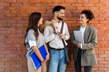 İş adamlarından oluşan bir ekip ofis binasının önünde konuşuyor. Personel toplantısı. Çalışanların motivasyon konuşması hakkında ofis çalışanlarını bilgilendirme toplantısı. İş adamı ve iş kadını fırsatları tartışıyor