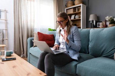 Genç iş kadını, şirketinin çalışanlarıyla yaptığı bir video görüşmesinde onlara motive edici bir konuşma yapıyor ve iş yerinde çalışırken nasıl mutlu olacakları konusunda tavsiyelerde bulunuyor.