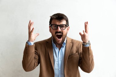 Gülümseyen Genç İşadamı, gözlük takmış, Gri Duvara Karşı Kamera 'ya fotokopi uzayı ile bakıyor. Resmi Takma Portrede Başarılı İş İnsanı